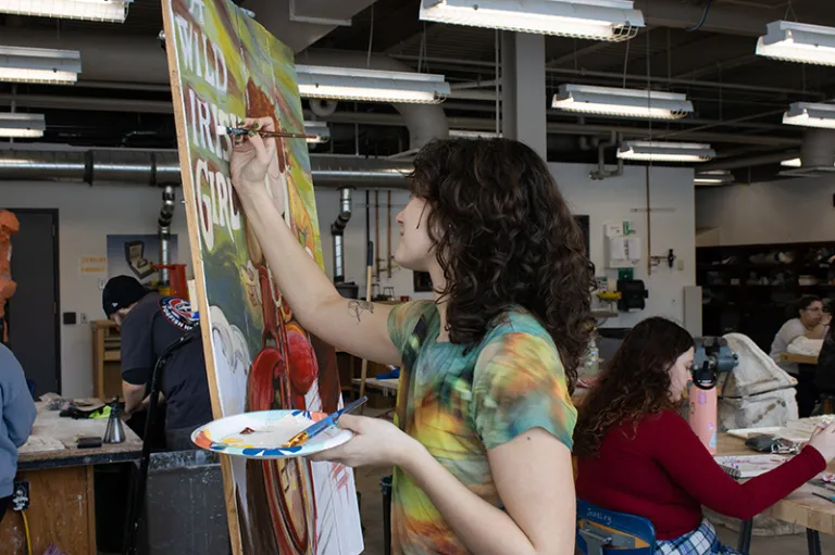 student painting on a canvas